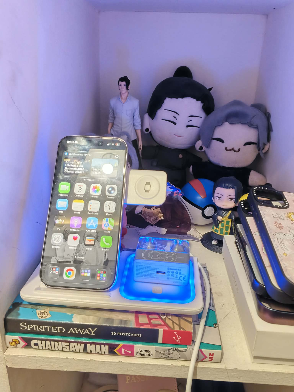 A customer's phone charging on the 3-in-1 stand inside a shelf nook, beside plushies